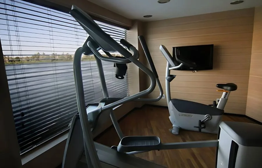 The gymnasium of the MS Le Fayan, including a cross-trainer and stationary bike.