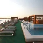 The sun deck of MS Le Fayan featuring lounge chairs, a swimming pool, and shaded.