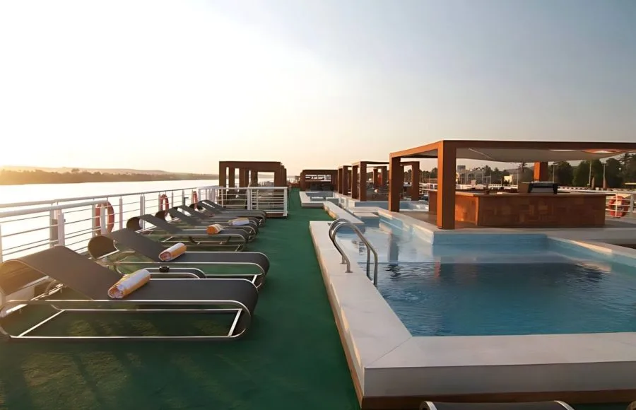 The sun deck of MS Le Fayan featuring lounge chairs, a swimming pool, and shaded.