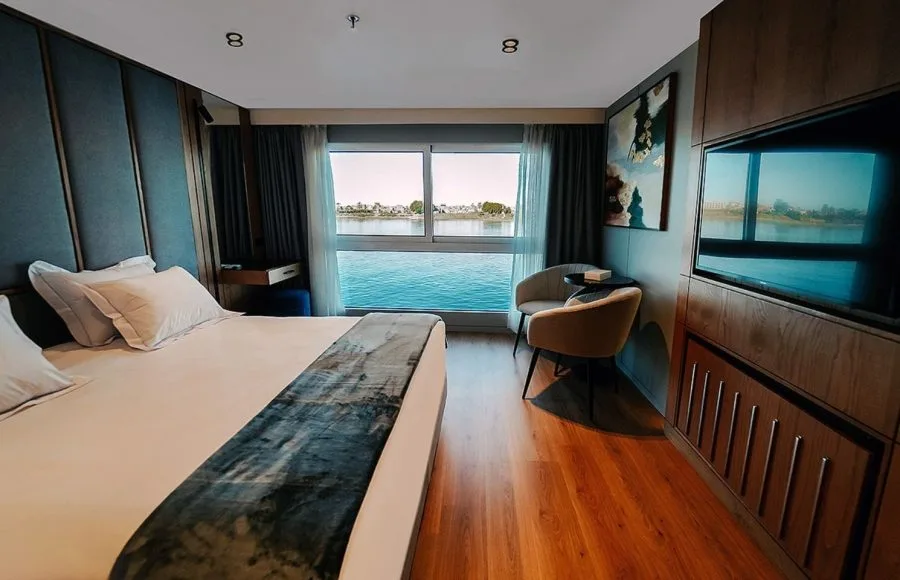 A beautifully appointed royal cabin on the MS Miriam nile cruise ship featuring a large bed and panoramic river views