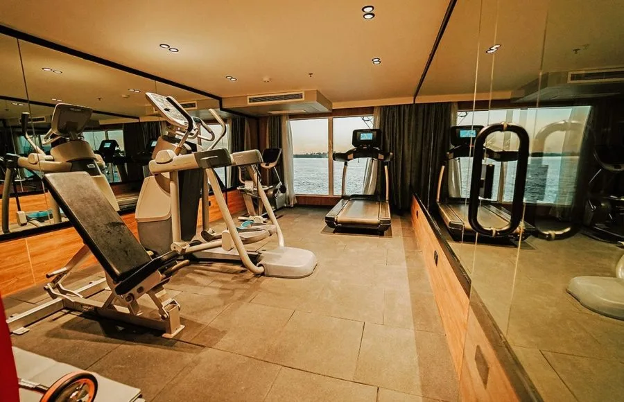 A fully equipped gym with treadmills and exercise machines overlooking the Nile river on the MS Miriam Nile Cruise