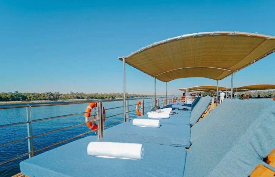 Guests relaxing on comfortable sun loungers under a shaded canopy on the sun deck of the MS Miriam Nile Cruise