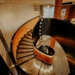 The elegant and contemporary spiral staircase with marble steps and modern lighting aboard the MS Miriam nile cruise ship