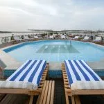 The sun deck pool and striped loungers with a river backdrop on the luxurious MS Miriam nile cruise ship