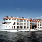 Exterior of Nile cruise ship docked, featuring orange and white facade.
