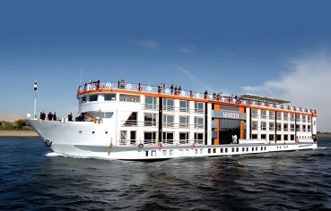 Exterior of Nile cruise ship docked, featuring orange and white facade.