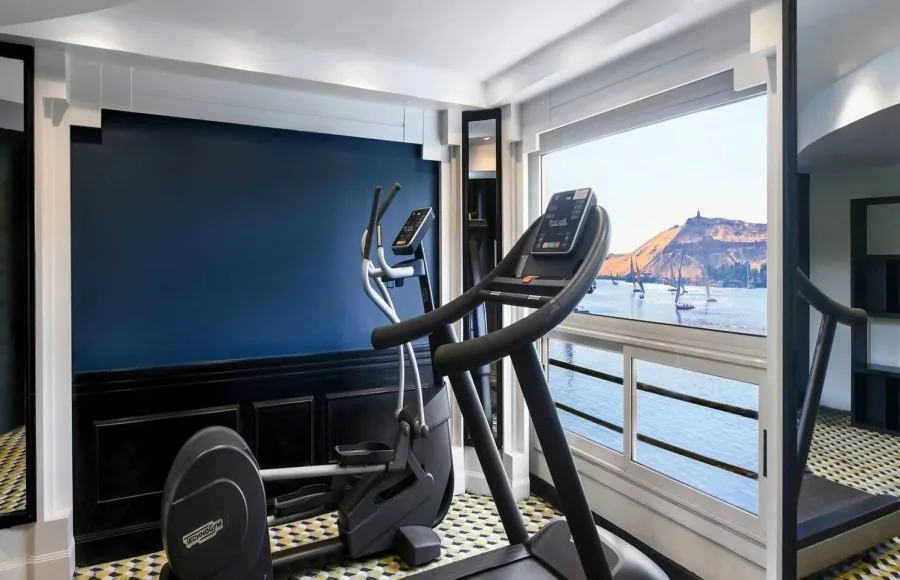 The onboard gymnasium of the Movenpick Hamees Nile Cruise allows guests to exercise while enjoying panoramic river and scenic landscape views.
