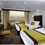 Twin-bedded cabin on the Movenpick Royal Lily Nile Cruise featuring a large window with river views