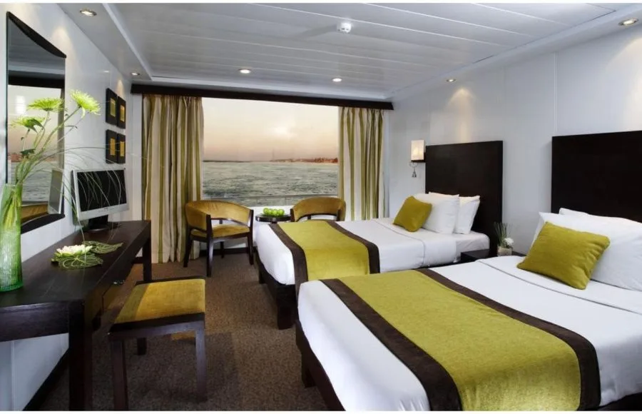 Twin-bedded cabin on the Movenpick Royal Lily Nile Cruise featuring a large window with river views