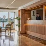 The bright and elegant reception desk on the Ms Royal Lotus Nile Cruise with a staff member ready to assist