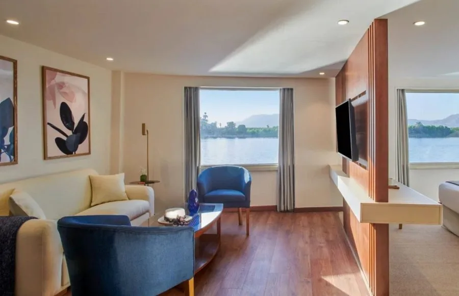 The elegantly designed suite on the Movenpick Royal Lotus Nile Cruise featuring large windows and comfortable seating