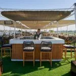 A bartender prepares a drink at the stylish sun deck bar on the ms movenpick royal lotus nile cruise overlooking the river.