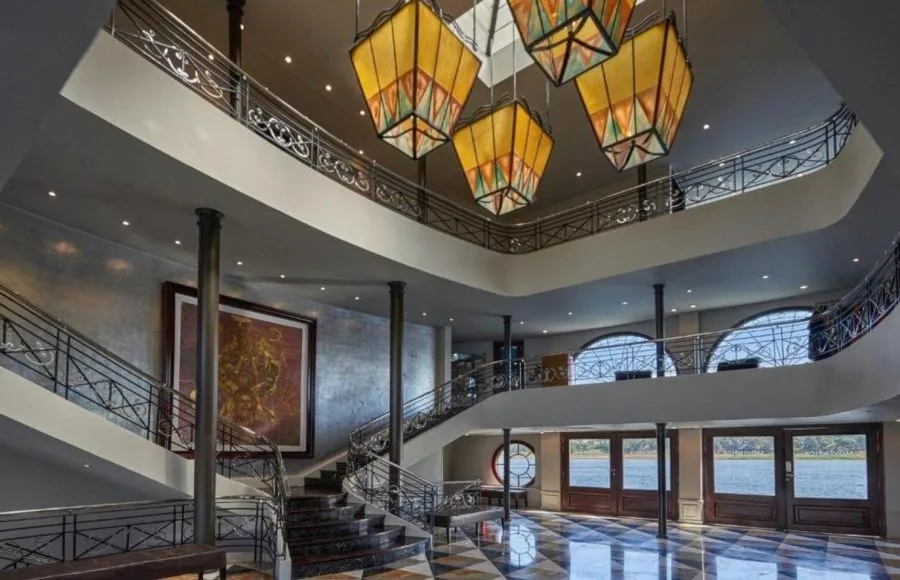 The grand, two-story lobby of the Movenpick MS Sunray with a curved staircase and distinctive Moroccan-style lamps.