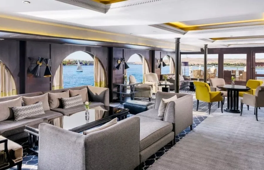 The comfortable and modern lounge on the Movenpick MS Sunray with arched windows providing scenic views of the Nile River.