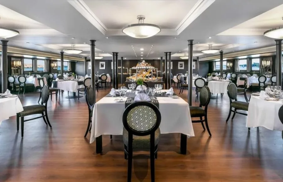 The elegant main restaurant on the Movenpick MS Sunray set with tables and a central buffet for dining on the Nile Cruise.