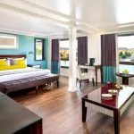 Movenpick MS Sunray suite featuring a luxurious bed and large windows with a view of the Nile River cruise.