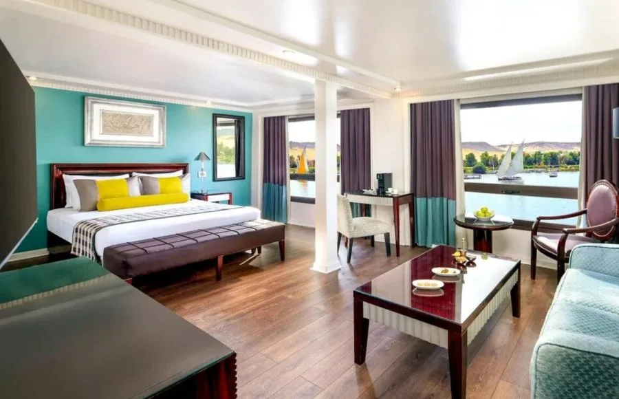 Movenpick MS Sunray suite featuring a luxurious bed and large windows with a view of the Nile River cruise.