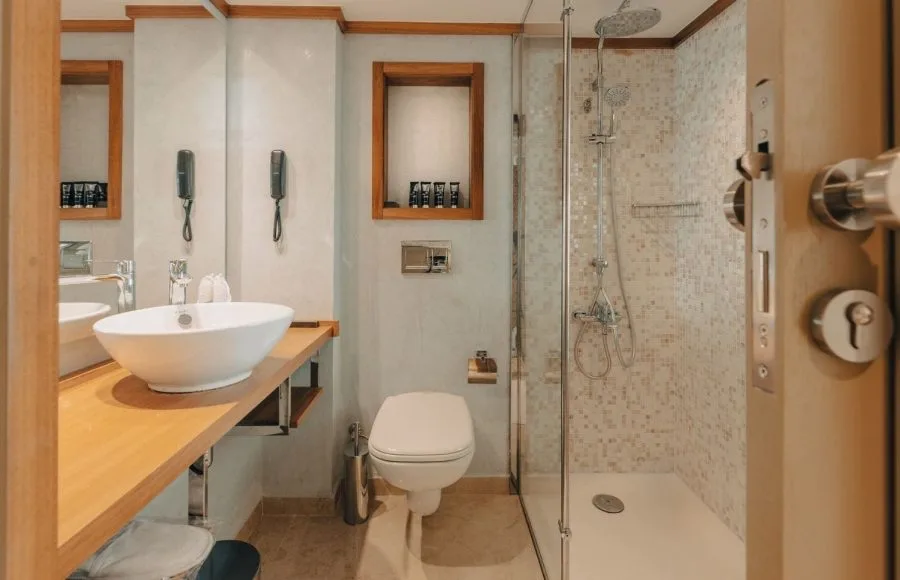 Nebu Nile Cruise cabin bathroom with shower, toilet, and modern sink.