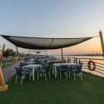 Outdoor dining area on a sundeck with a river sunset view.