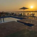 Sunset deck with a swimming pool and lounge chairs on a cruise ship.