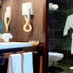 Luxurious bathroom featuring a sink, hairdryer, and plush bathrobe on the Ms Nile Premium cruise cabin ready for your comfort.