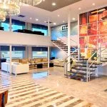 Grand lobby of the Ms Nile Premium cruise with a striking staircase, comfortable seating, and modern art reflecting its luxurious design.