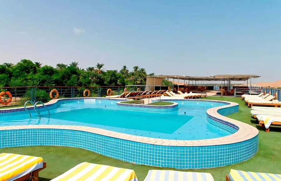 Sun-drenched swimming pool on the sundeck of the luxurious Ms Nile Premium cruise ship offering a relaxing spot with lounge chairs and views of the riverbank