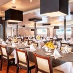 The bright and elegant main dining room of the MS Nile Style Cruise Ship set for a meal.
