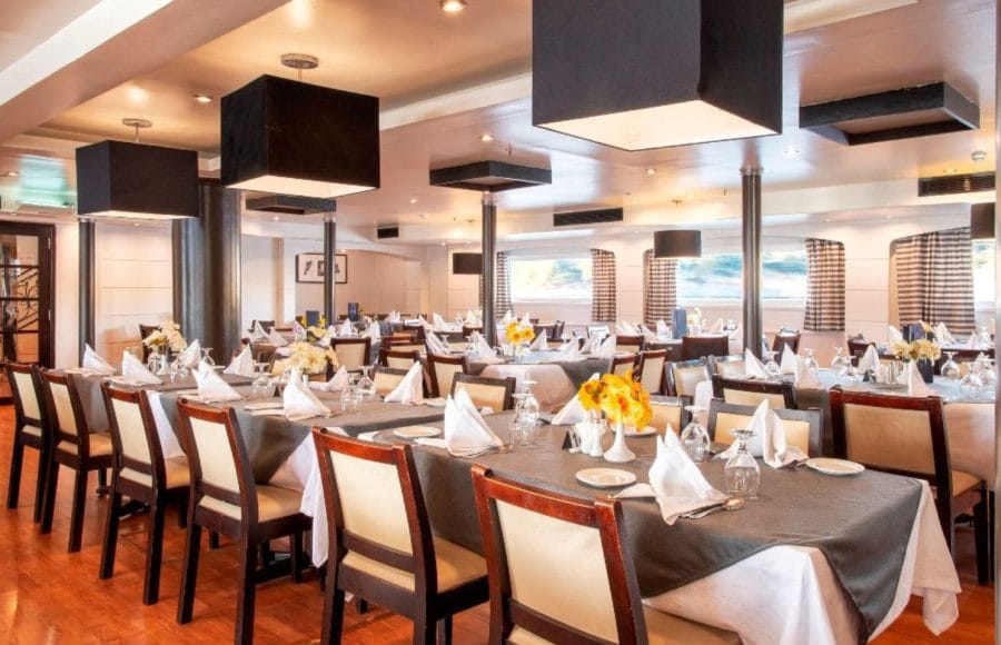 The bright and elegant main dining room of the MS Nile Style Cruise Ship set for a meal.