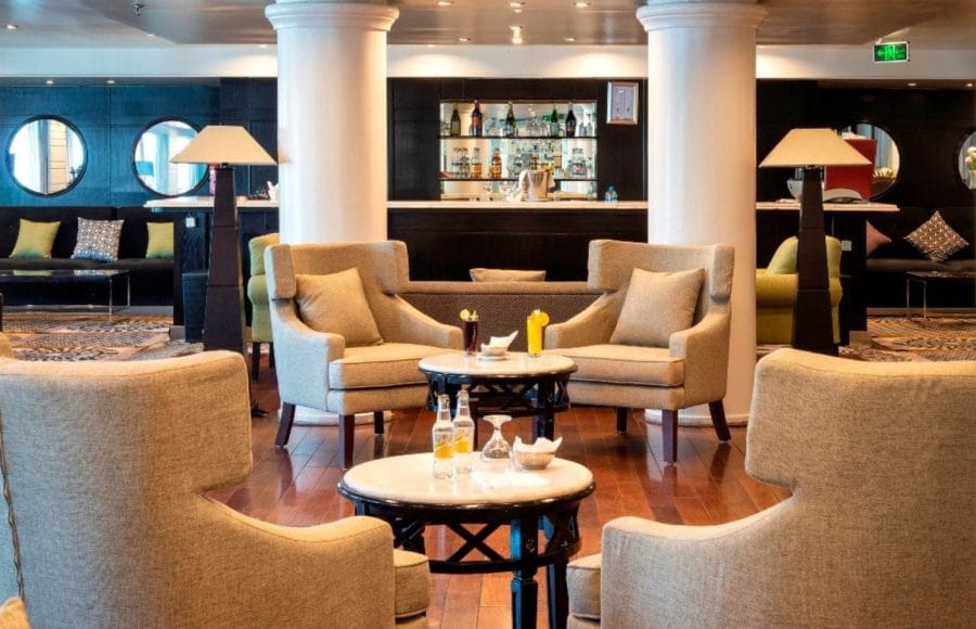 The cozy and stylish main lounge area aboard the MS Nile Style Cruise Ship with a bar in the background.