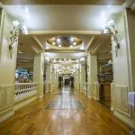 Elegant hallway with decorative wall sconces and wooden flooring on the Princess Sarah I Nile Cruise.