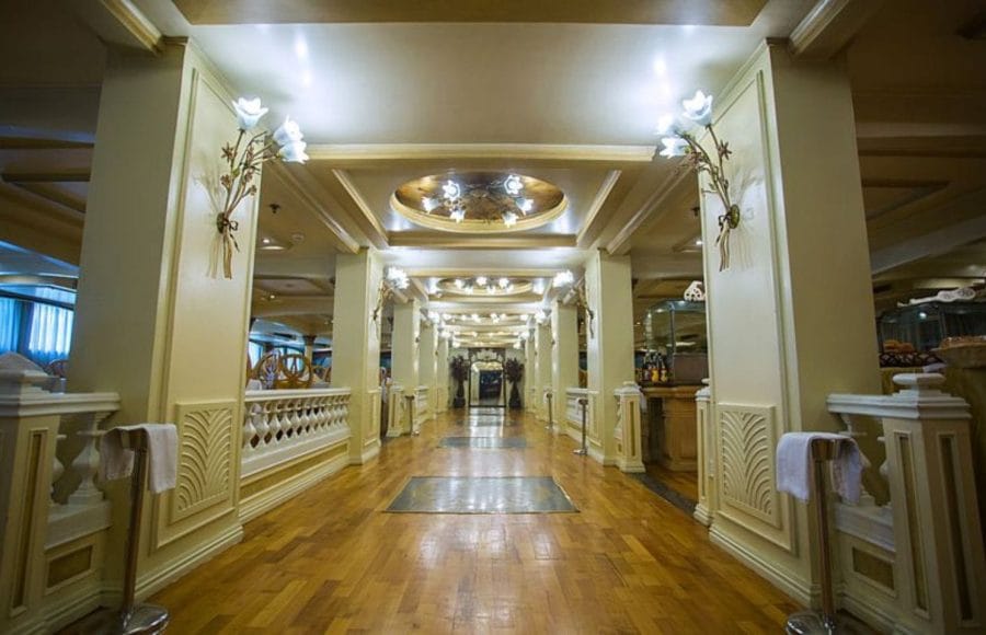 Elegant hallway with decorative wall sconces and wooden flooring on the Princess Sarah I Nile Cruise.