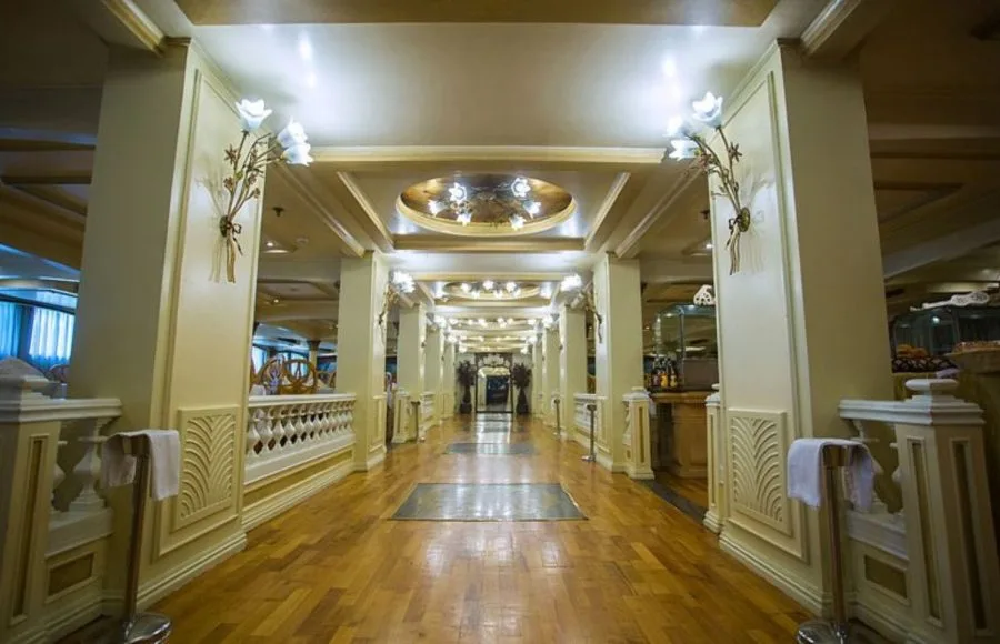 Elegant hallway with decorative wall sconces and wooden flooring on the Princess Sarah I Nile Cruise.