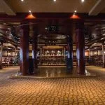 A spacious entertainment lounge with a stage, bar, and seating areas on the Princess Sarah I Nile Cruise.