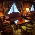 An intimate seating area with comfortable armchairs, a sofa, and lamps, on the Princess Sarah I Nile Cruise.