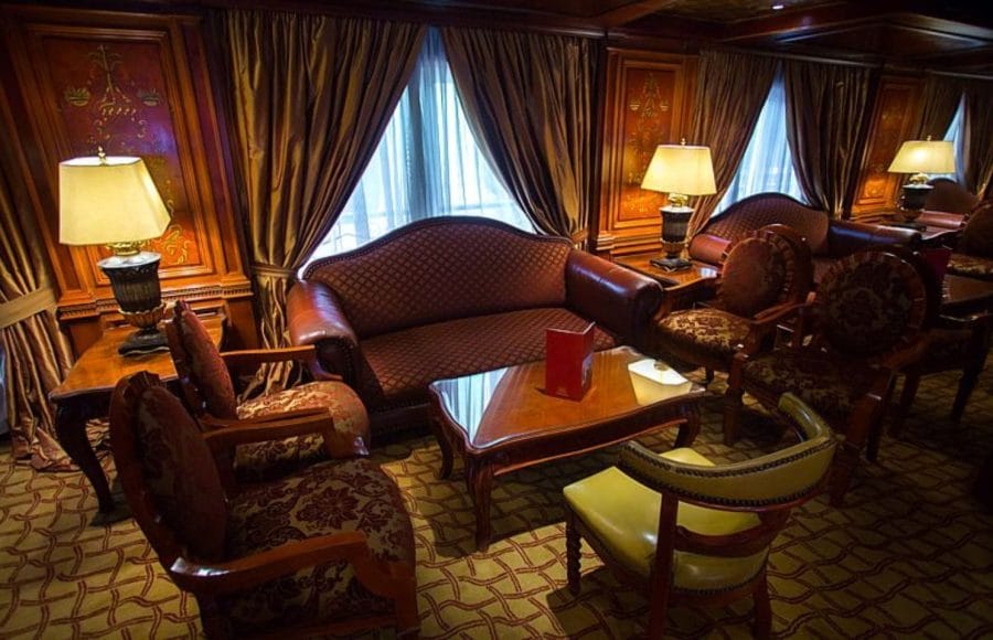 An intimate seating area with comfortable armchairs, a sofa, and lamps, on the Princess Sarah I Nile Cruise.