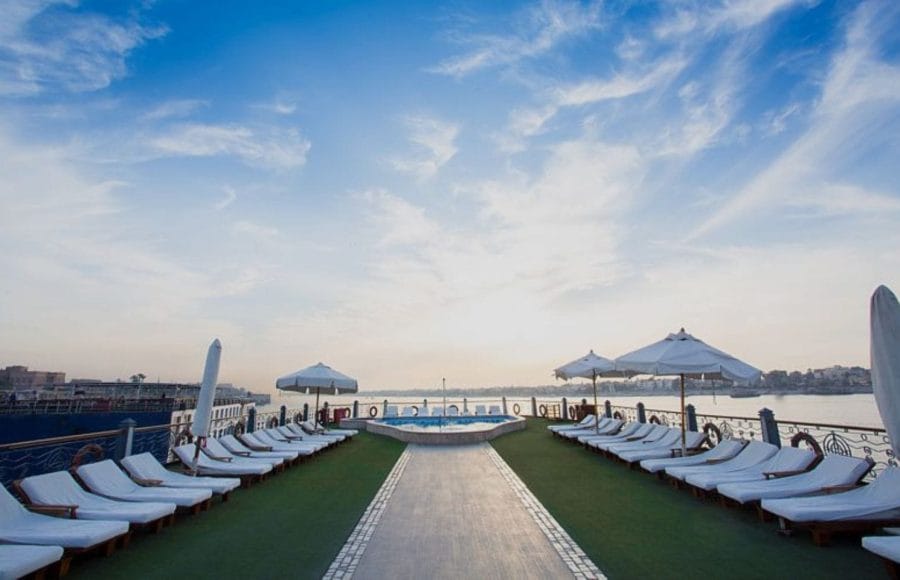 The sun deck of the Princess Sarah I Nile Cruise, with many sun loungers and a sparkling pool.