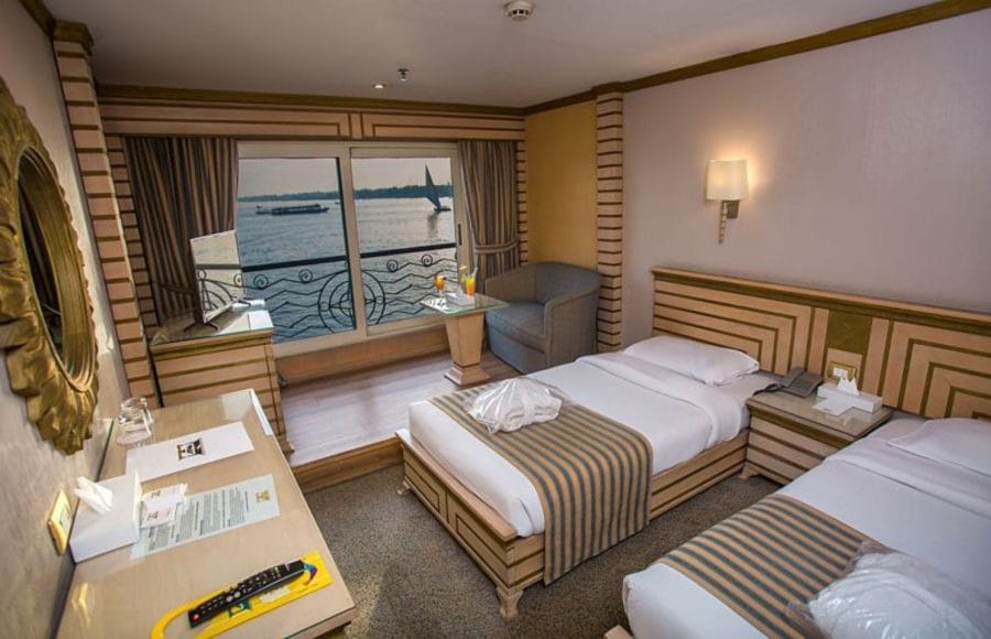 A comfortable twin cabin on the Princess Sarah I Nile Cruise with two beds and a Nile view balcony.
