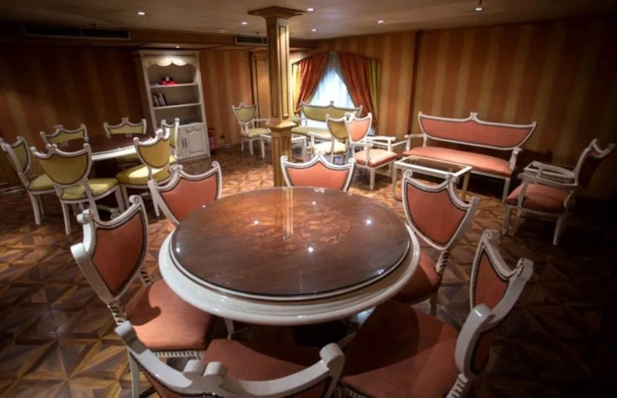 A quiet reading lounge with a large round table on the Princess Sarah II Nile Cruise.