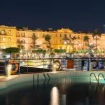 Luxor's Sofitel Winter Palace Hotel at night viewed from an adjacent Nile cruise ship pool.