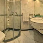 Dramatic two-story lobby with a gold and black fan-themed reception desk and a circular stained-glass ceiling dome.
