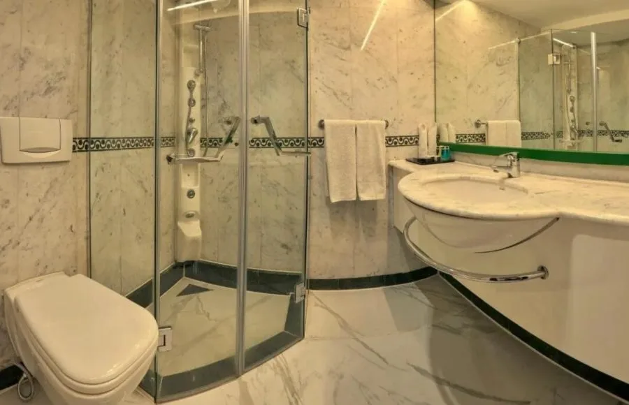 Dramatic two-story lobby with a gold and black fan-themed reception desk and a circular stained-glass ceiling dome.