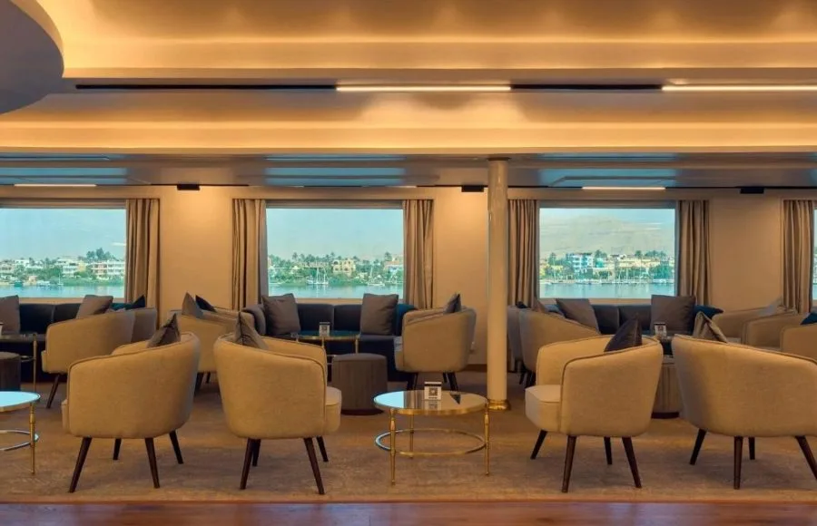 Modern, comfortable lounge area with plush chairs and large windows overlooking a waterfront view.