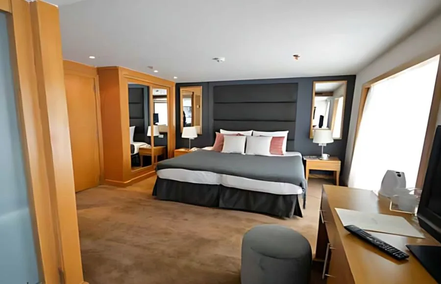 A luxurious cabin aboard the MS Salima Nile Cruise, featuring a king-sized bed and elegant furnishings