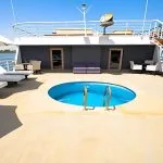 A small, inviting swimming pool on the sun deck of the MS Salima Nile Cruise, surrounded by sun loungers