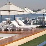 Relax under the sun on the spacious deck of the Salima Nile Cruise, featuring comfortable loungers and umbrellas for ultimate comfort as you sail.
