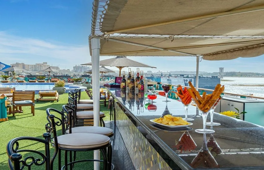 The vibrant bar area on the sun deck of the Sonesta Moon Goddess Nile Cruise ship, serving refreshing drinks and snacks next to the pool.