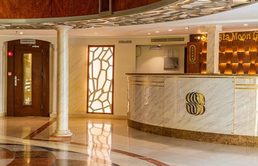 The welcoming reception area of the Sonesta Moon Goddess Nile Cruise ship, featuring a elegant marble counter and warm lighting.