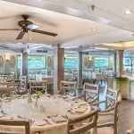 The spacious dining room of the Sonesta Moon Goddess Nile Cruise ship, featuring elegantly set tables and large windows offering river views.