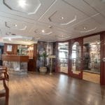 The sophisticated lobby of the Sonesta Nile Goddess Cruise with a polished wooden reception desk and a staircase leading to the upper deck.